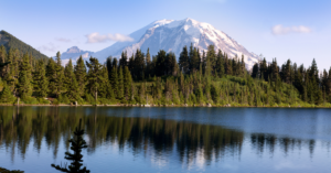 A photo of a lake with trees and a mountain in backround